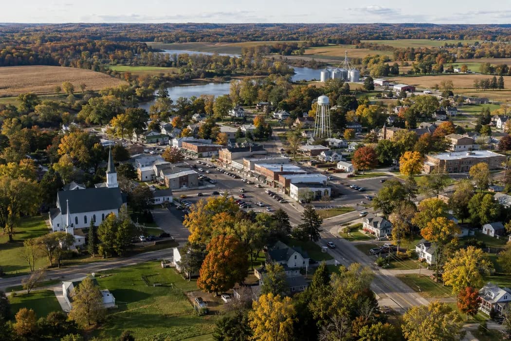 Aerial oblique view of modest Midwestern small town surrounded by fields, not an identifiable real place